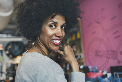 Side view portrait of happy female mechanic in workshop