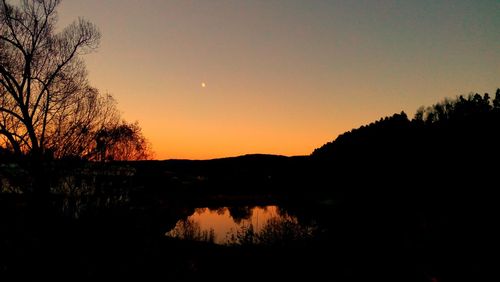 Scenic view of lake against sky at sunset