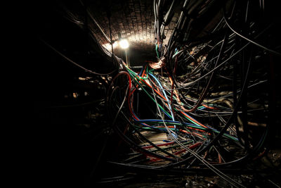 Close-up of illuminated lighting equipment against black background