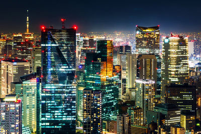 Illuminated buildings in city against sky at night