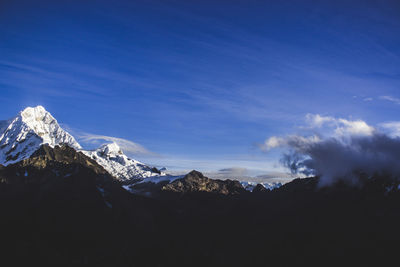 Scenic view of snowcapped mountains against blue sky