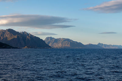 Scenic view of sea and mountains against sky