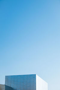 Low angle view of modern building against clear blue sky