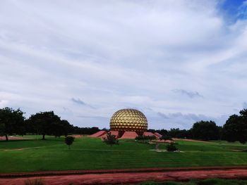 Traditional windmill on field against sky