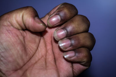 Close-up of human hand against blue background