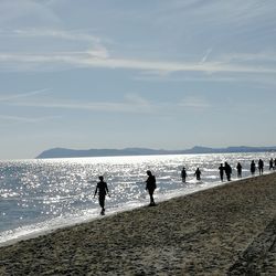 People on beach against sky
