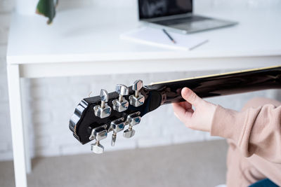 Midsection of man playing guitar