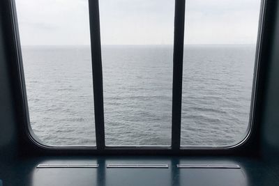 Scenic view of sea against sky seen through window