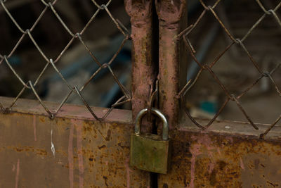 Close-up of padlock on rusty metal