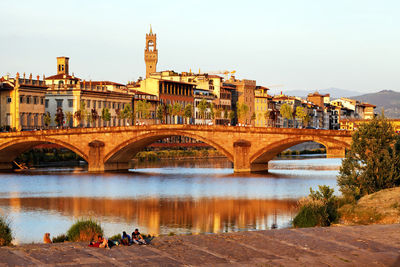 Ponte alla carraia over arno river by residential buildings against sky