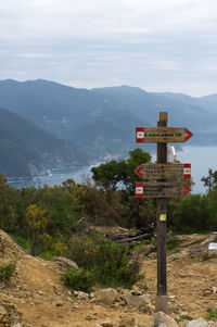 Information sign on mountain against sky