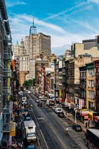 Traffic on city street and buildings against sky