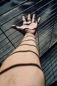 Man hand grabbing a metallic fence on the street