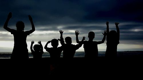 Silhouette of people against cloudy sky