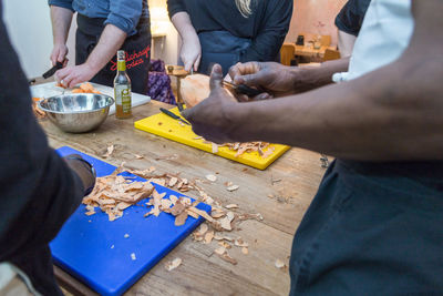 Midsection of people preparing food in kitchen