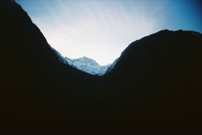 Silhouette mountains against clear sky during winter
