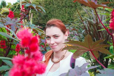 Portrait of young woman amidst flowering plants