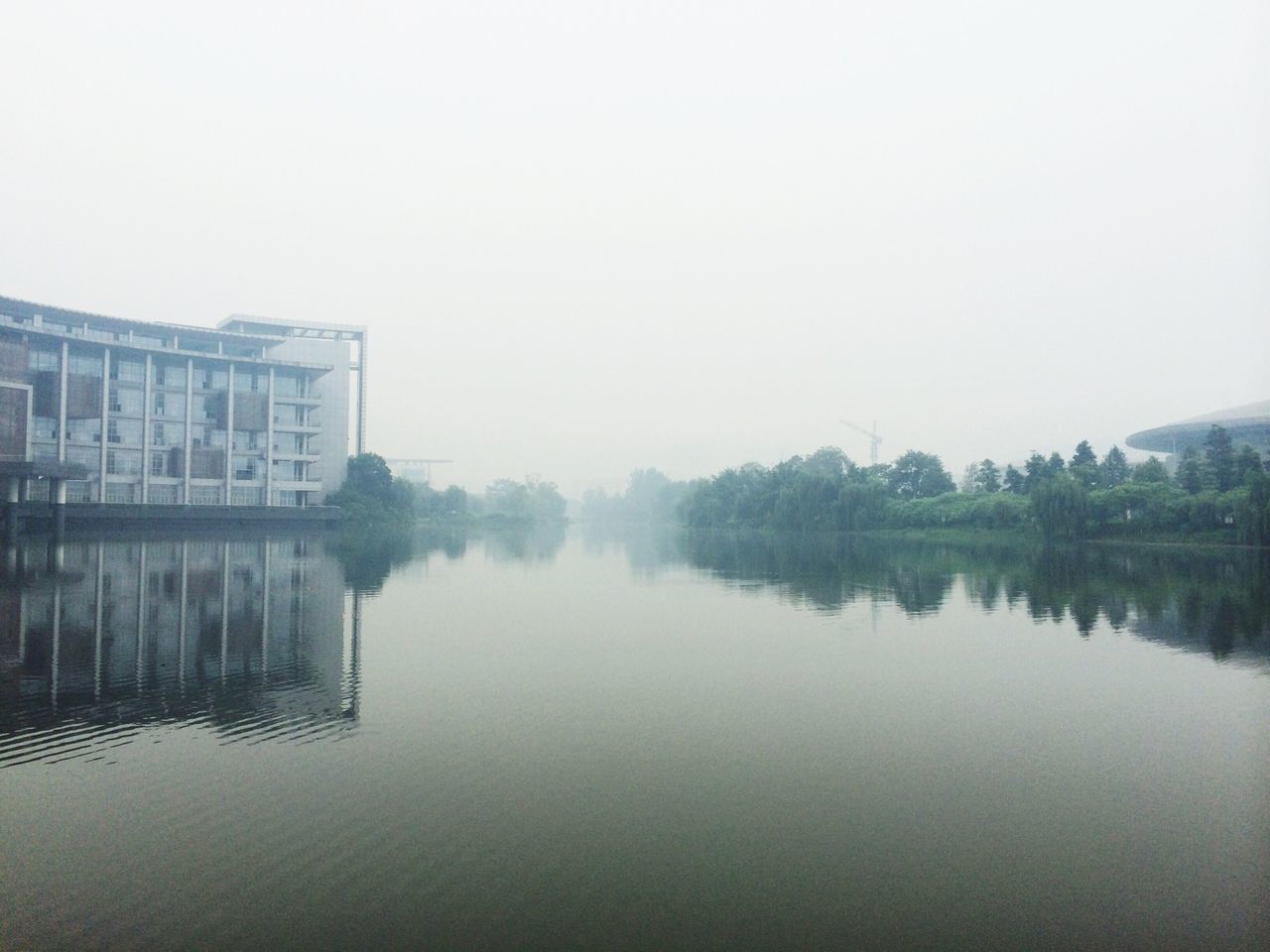 water, reflection, waterfront, clear sky, lake, copy space, built structure, architecture, building exterior, tranquility, tranquil scene, river, nature, sky, standing water, day, scenics, beauty in nature, outdoors, calm