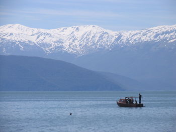 Scenic view of sea and snowcapped mountains against sky