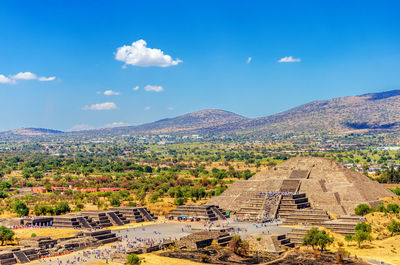 People at moon pyramid against sky