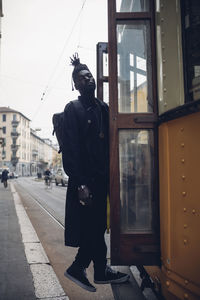 Man standing on street against building in city