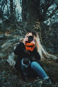 Young woman photographing with camera outdoors