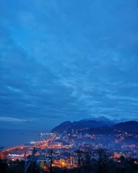 Illuminated cityscape against sky at night