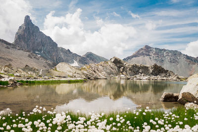 Scenic view of lake and mountains against cloudy sky