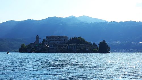 Scenic view of lake by buildings against sky