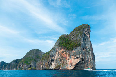 Rock formations by sea against sky