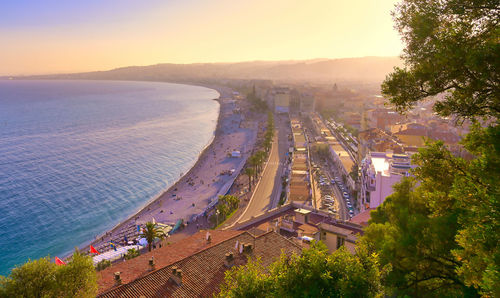 High angle view of city by sea against sky