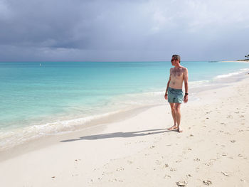 Full length of woman on beach against sky