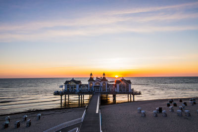 People on beach against sky during sunset