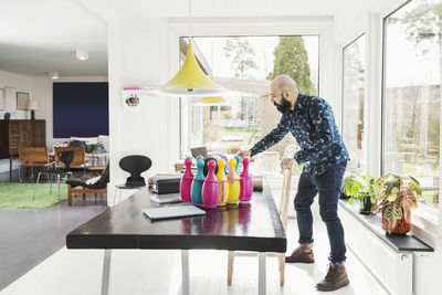 Full length of male architect standing at table in home office