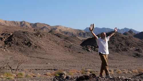 Senior man arms raised in the desert 