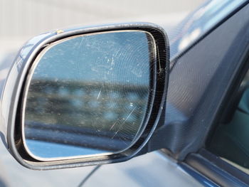 Close-up of spider web on side-view car mirror