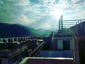 Houses by mountains against sky