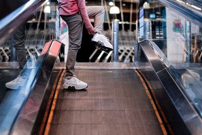 A girl skater on an escalator at the mall