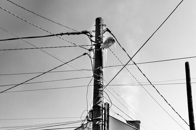 Low angle view of electricity pylon against sky