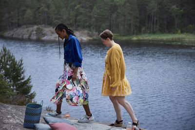 Female couple walking on cliff by river