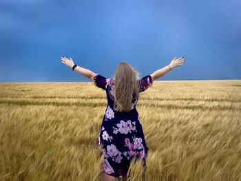 Rear view of woman standing on field