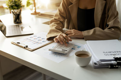 Midsection of businessman working at desk in office