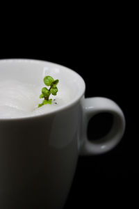 Close-up of coffee cup against black background