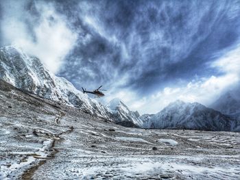 Scenic view of helicopter in front ofsnowcapped mountains against sky, near everest base camp, nepal