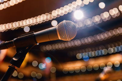 Low angle view of illuminated lighting equipment hanging on ceiling