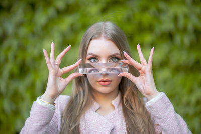 Portrait of beautiful young woman holding glass slab