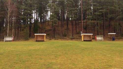 Built structure on field against trees in forest