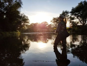 Side view of woman standing in lake