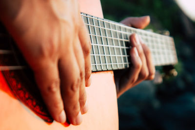 Close-up of person playing guitar