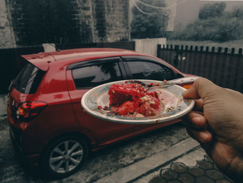 Midsection of person holding ice cream in city